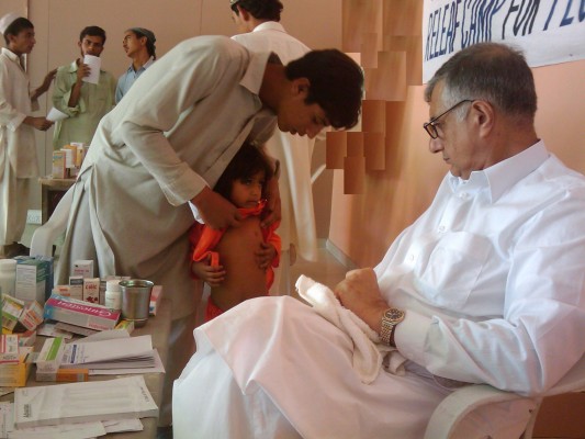 Dr. Miraj, dermatologist, examining a child. Skin diseases were common in flood affectees